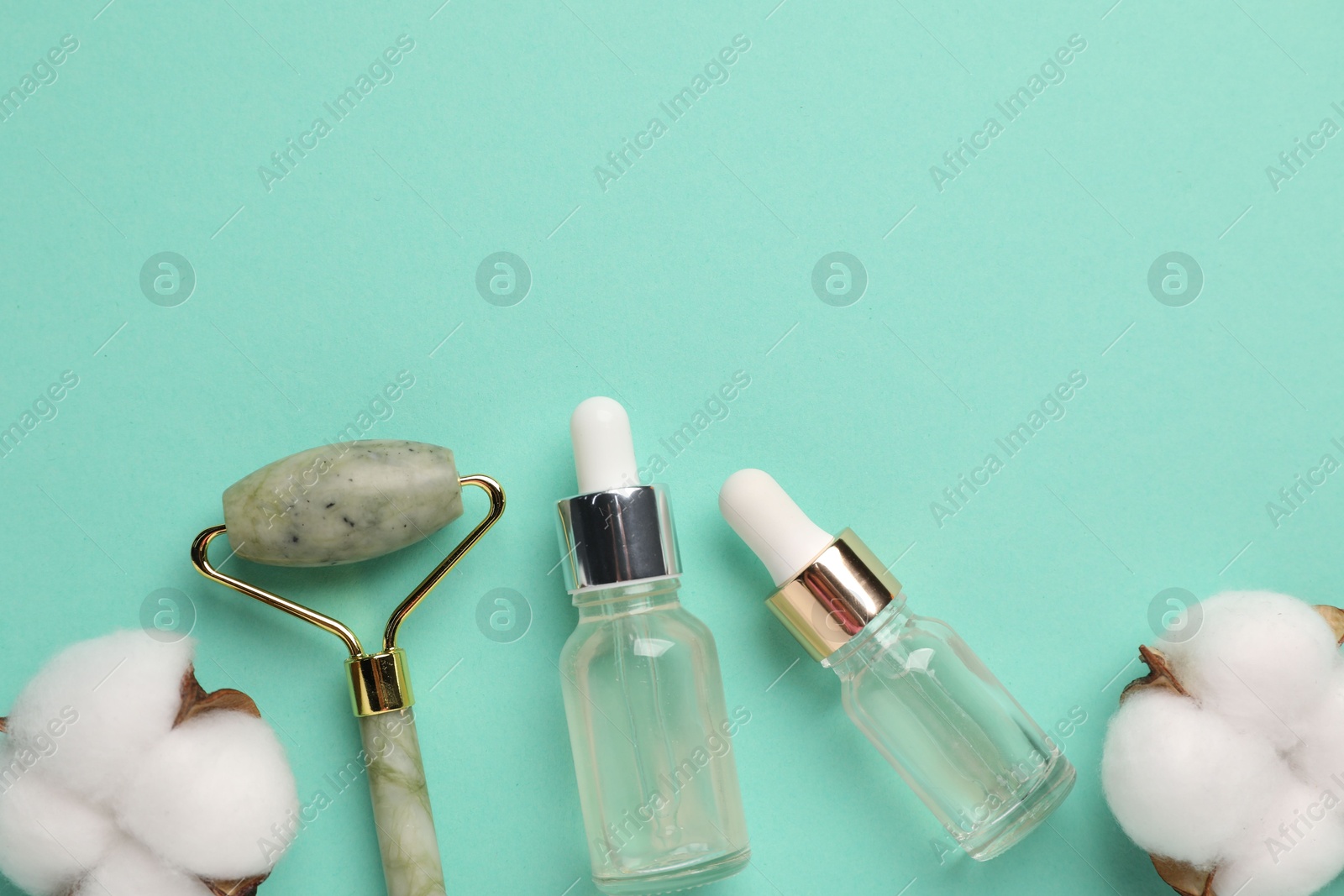 Photo of Different cosmetic products and cotton flowers on turquoise background, flat lay