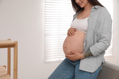 Photo of Pregnant woman in living room, closeup view