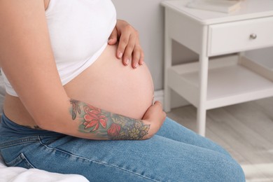 Pregnant woman on bed at home, closeup