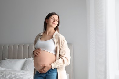 Photo of Beautiful pregnant woman at home, space for text