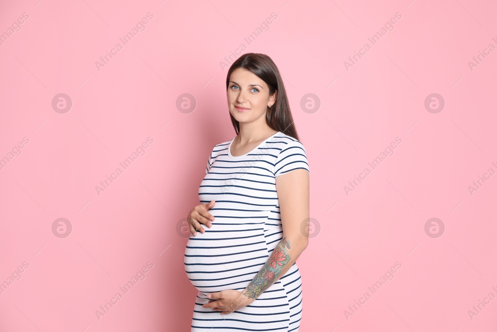 Photo of Portrait of beautiful pregnant woman on pink background