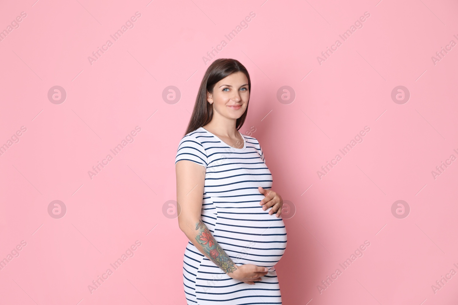 Photo of Portrait of beautiful pregnant woman on pink background