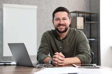 Photo of Consultant at table with laptop in office