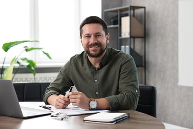 Consultant with pen at table in office