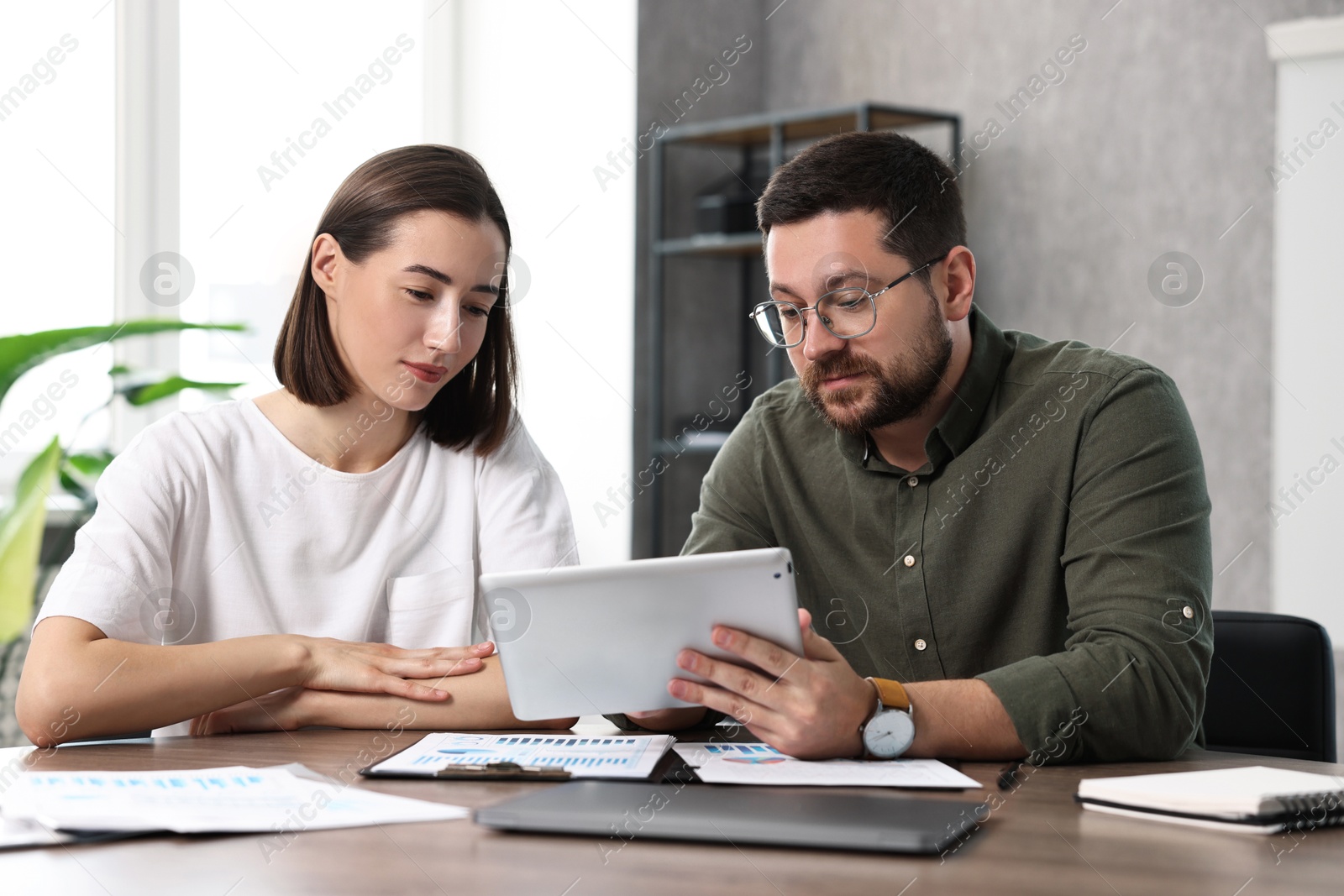 Photo of Consultant working with client at table in office