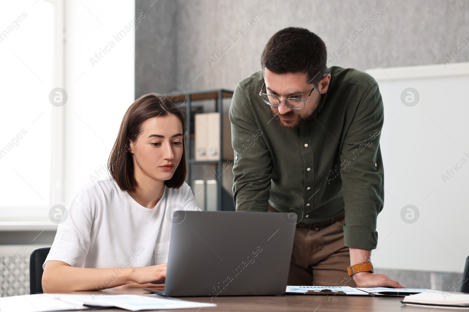 Photo of Consultant working with client at table in office