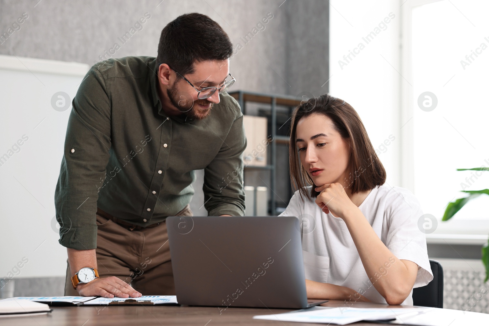 Photo of Consultant working with client at table in office