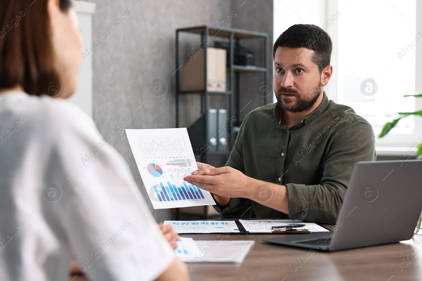 Photo of Consultant working with client at table in office