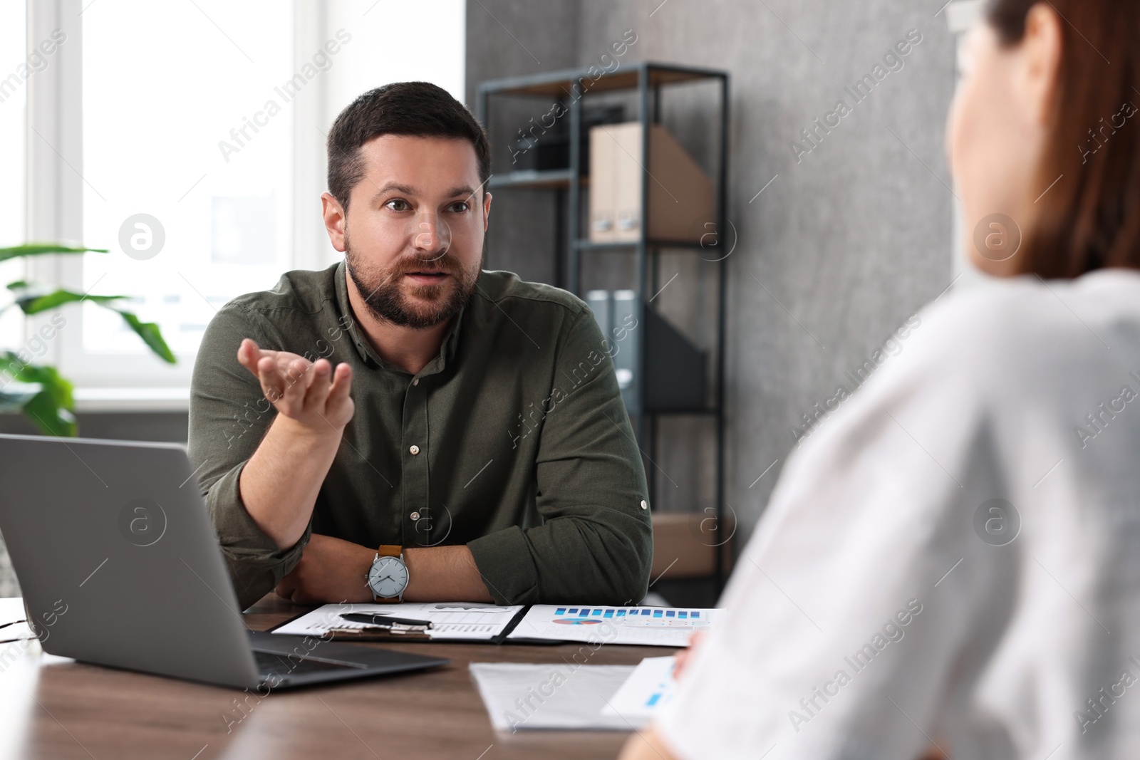 Photo of Consultant working with client at table in office