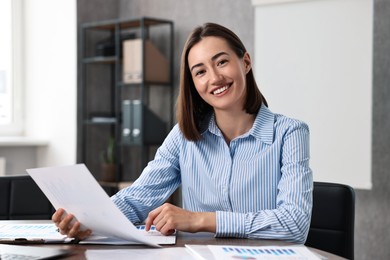 Photo of Consultant with document at table in office