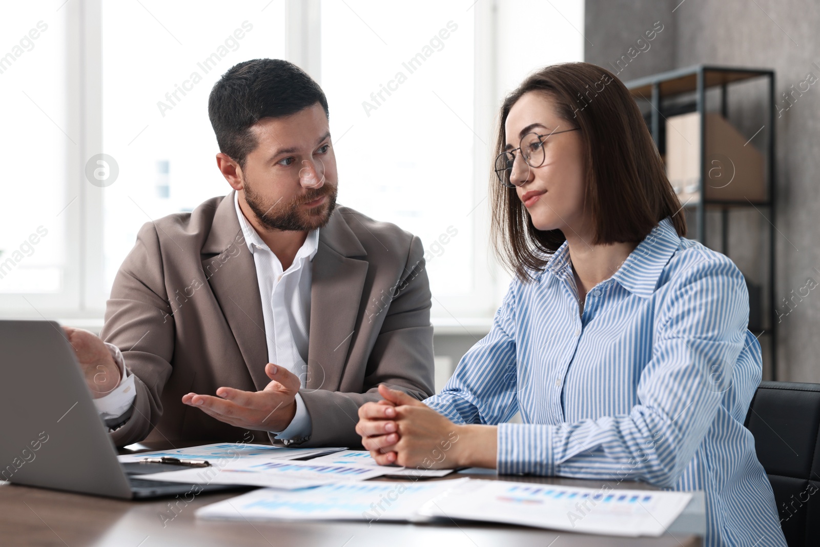 Photo of Consultant working with client at table in office