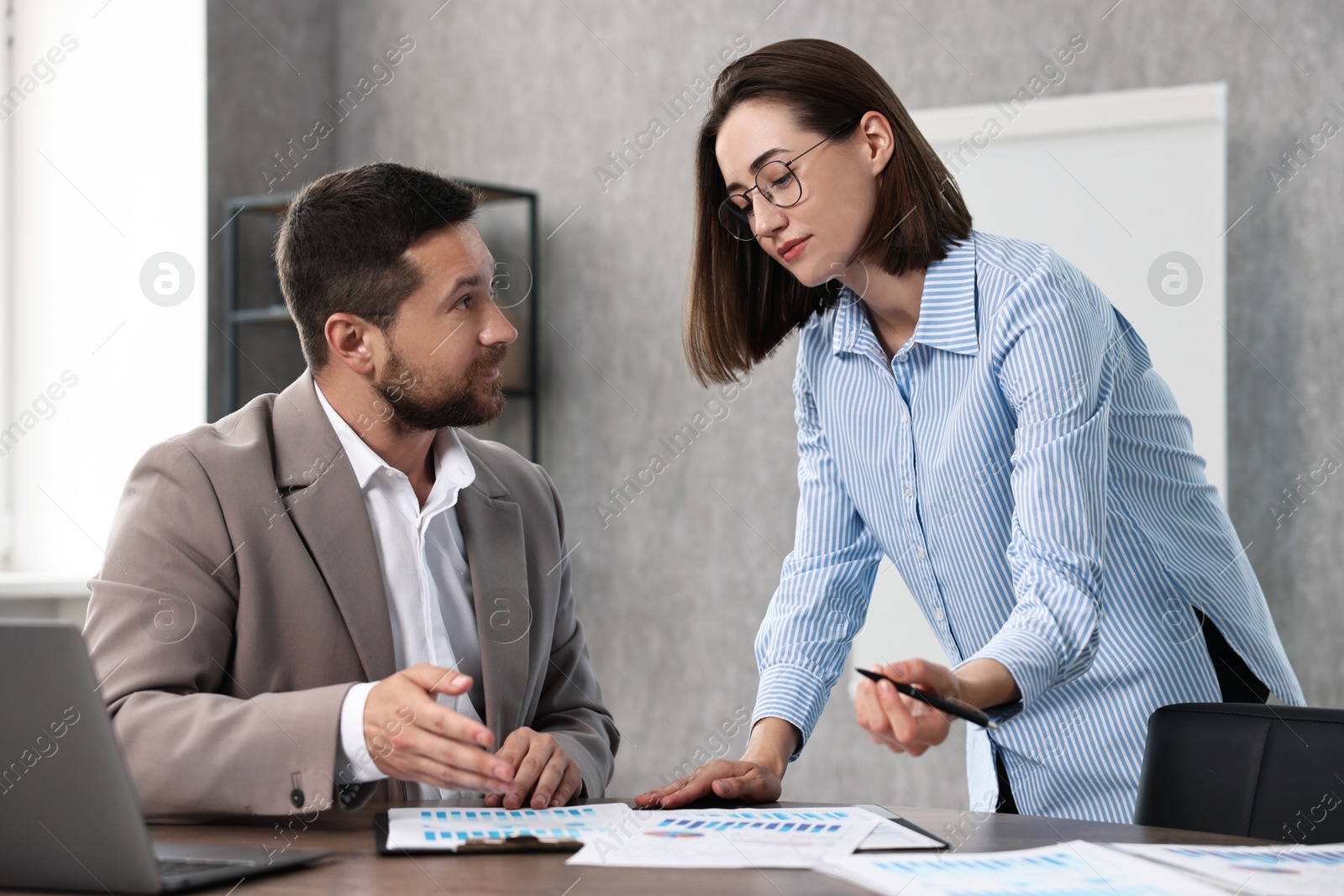 Photo of Consultant working with client at table in office