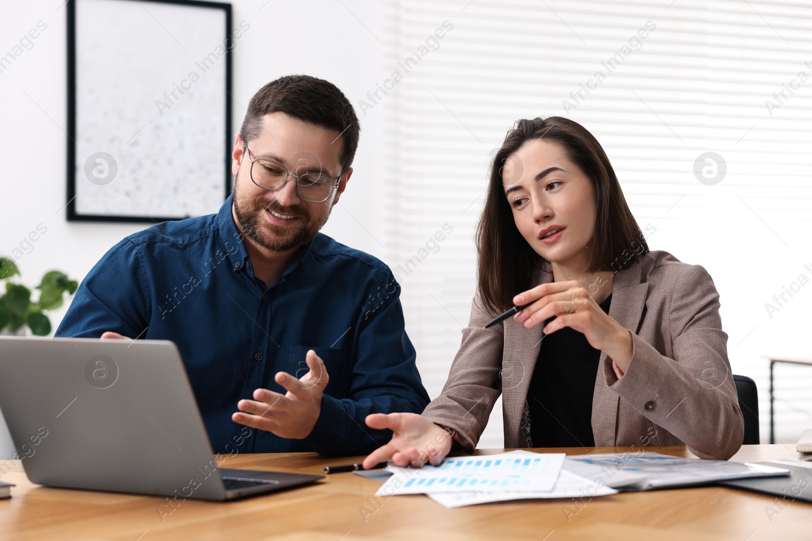 Photo of Consultant working with client at table in office