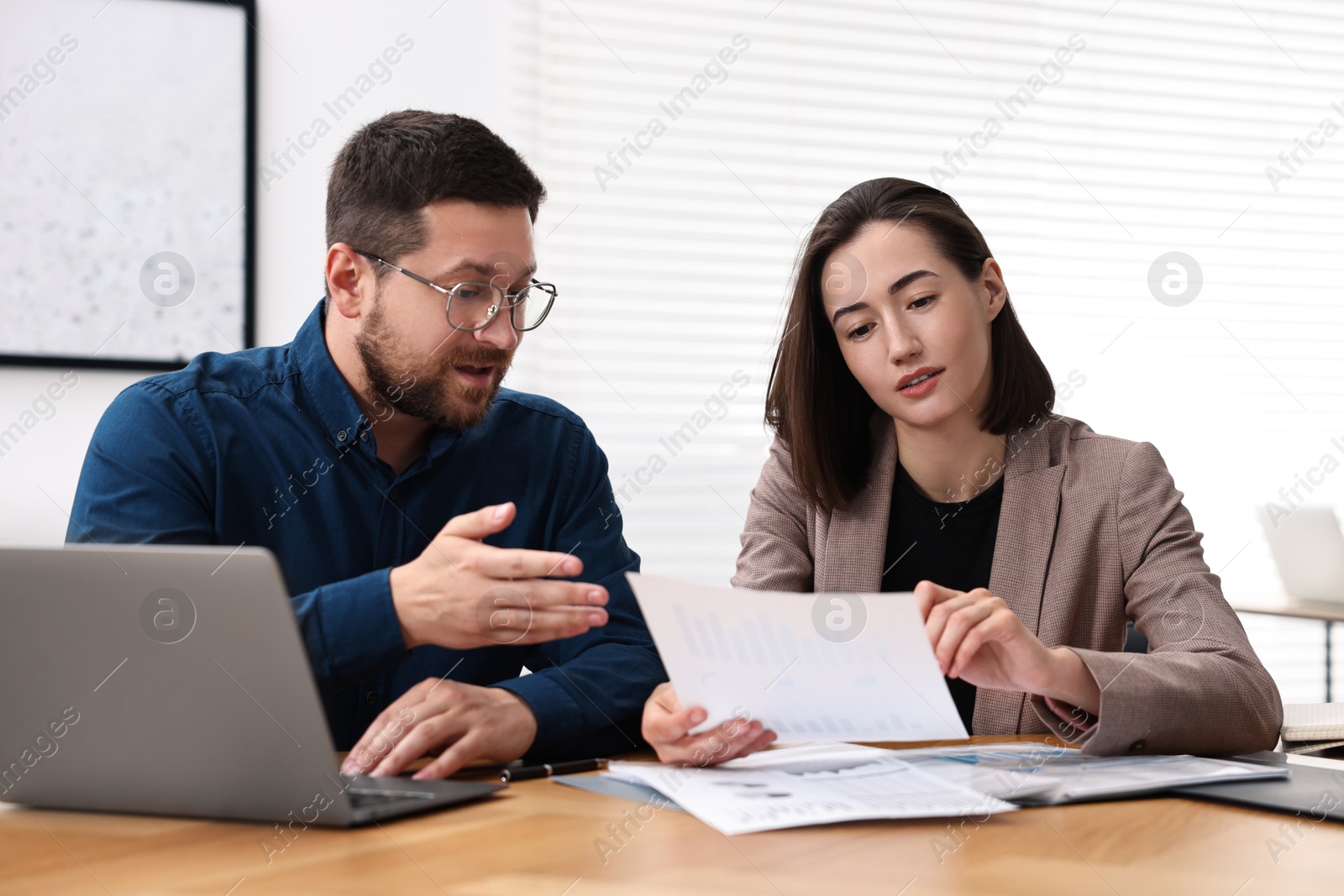 Photo of Consultant working with client at table in office