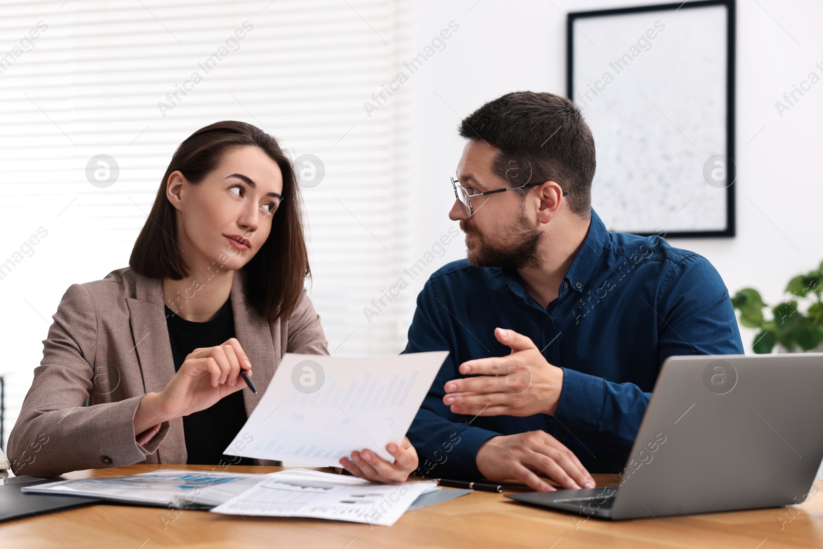 Photo of Consultant working with client at table in office