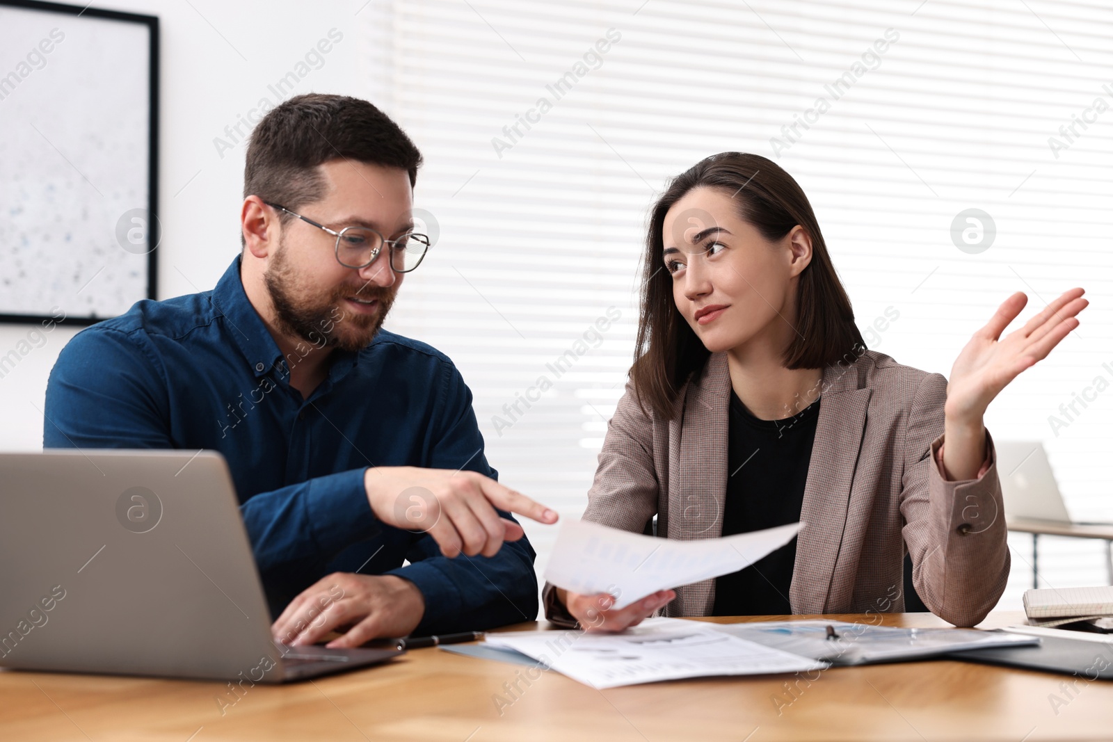 Photo of Consultant working with client at table in office