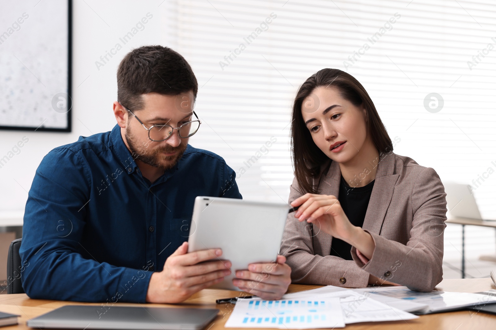 Photo of Consultant working with client at table in office