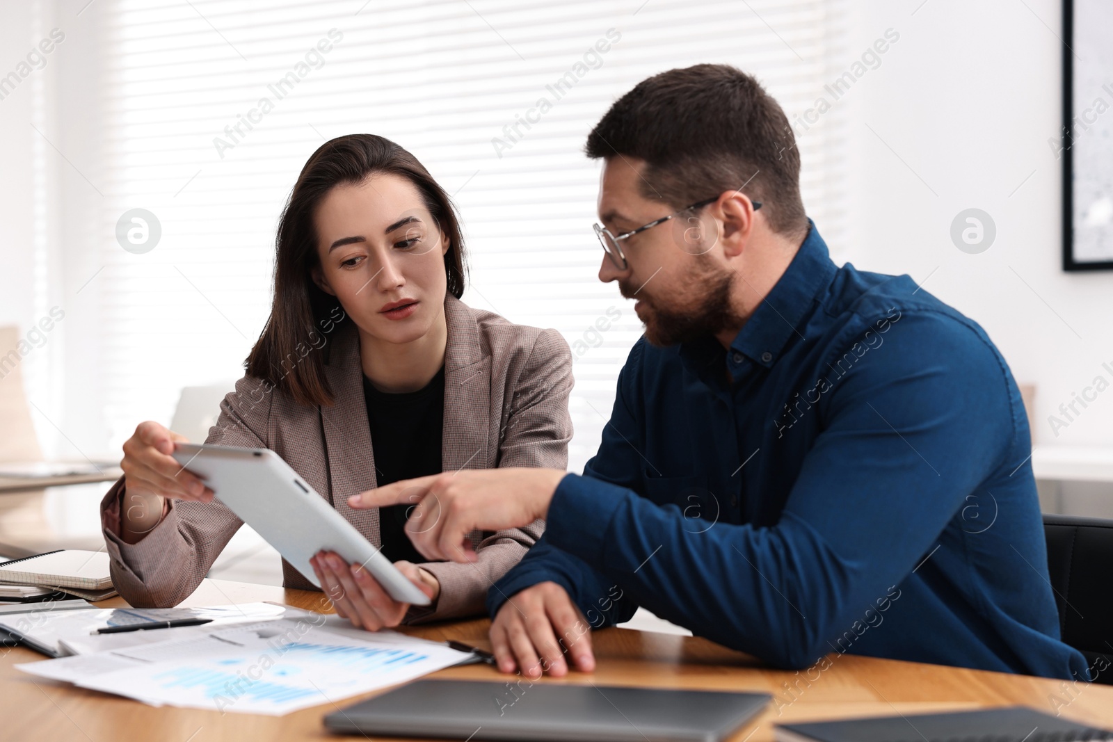 Photo of Consultant working with client at table in office