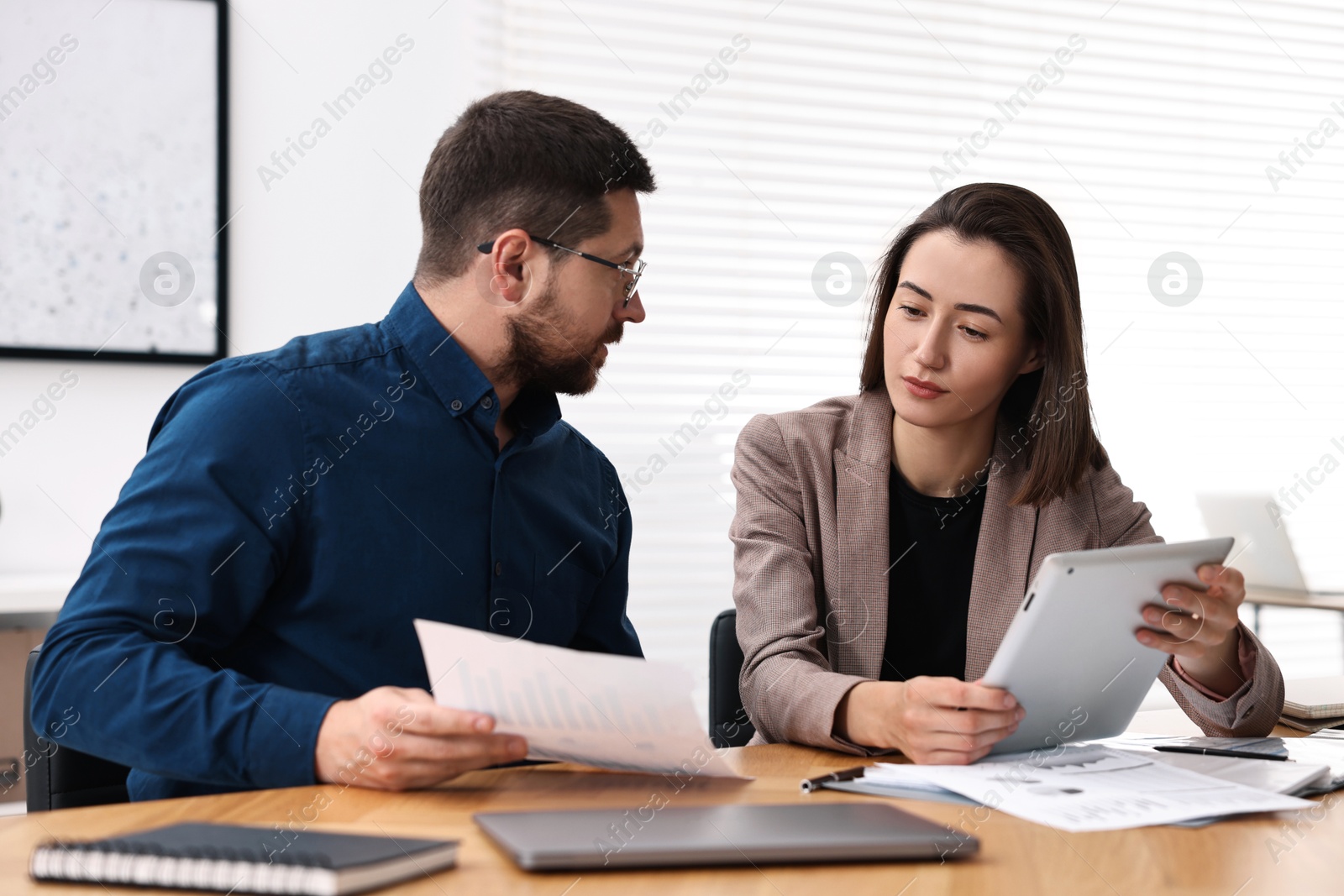 Photo of Consultant working with client at table in office