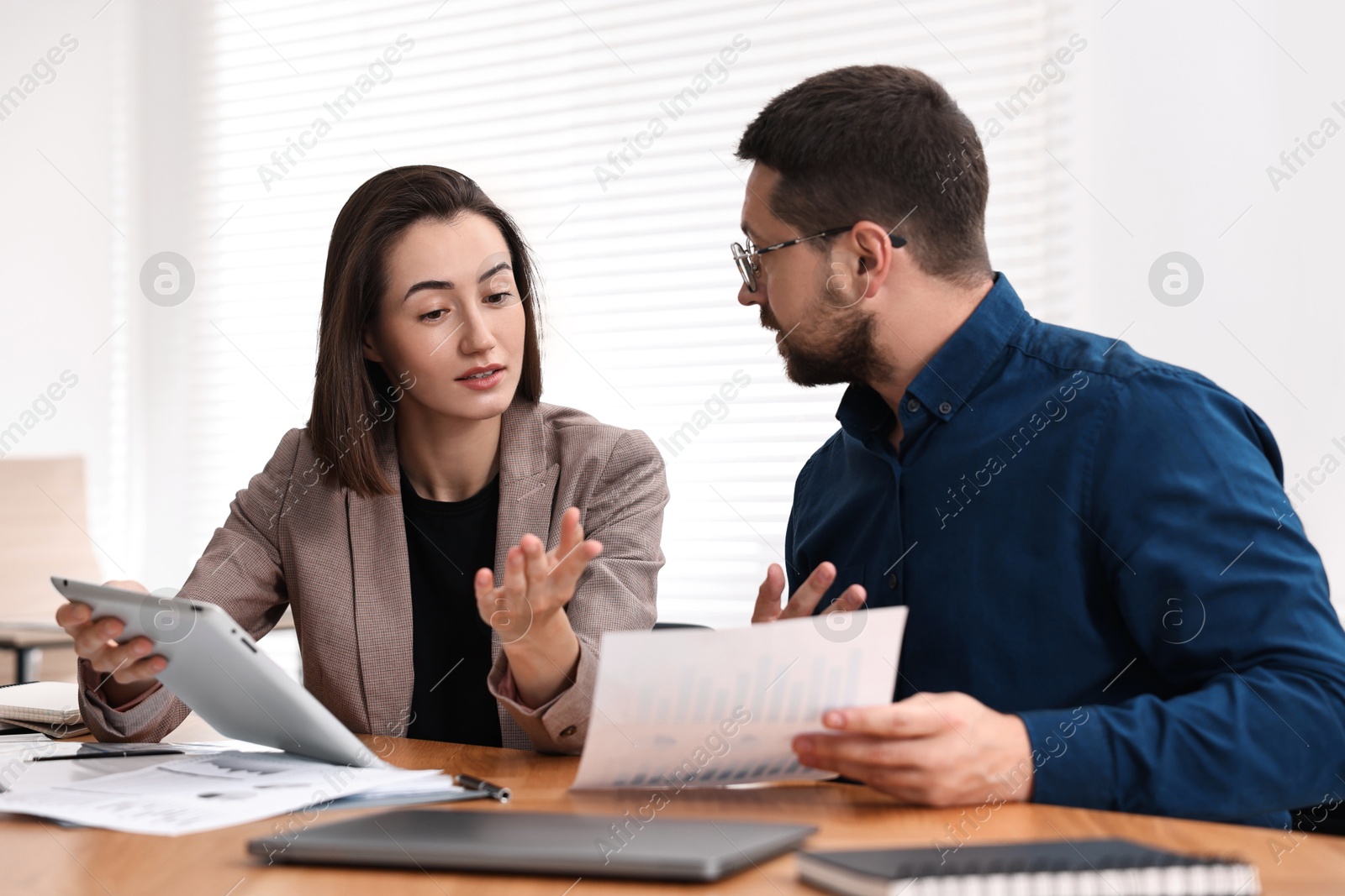 Photo of Consultant working with client at table in office