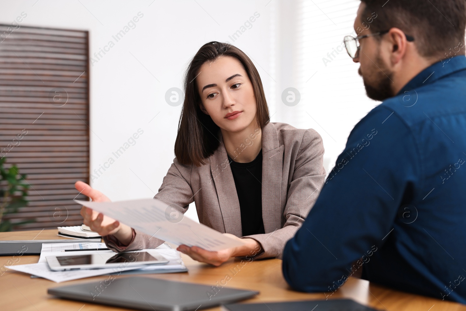 Photo of Consultant working with client at table in office