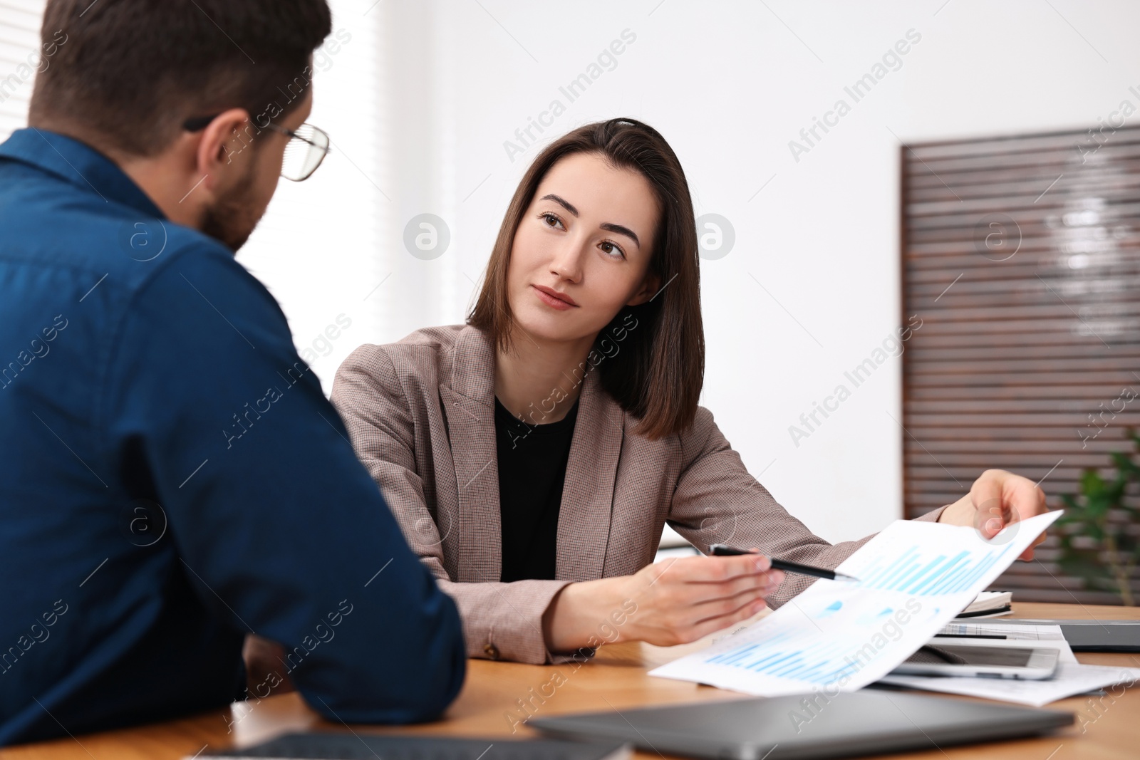 Photo of Consultant working with client at table in office