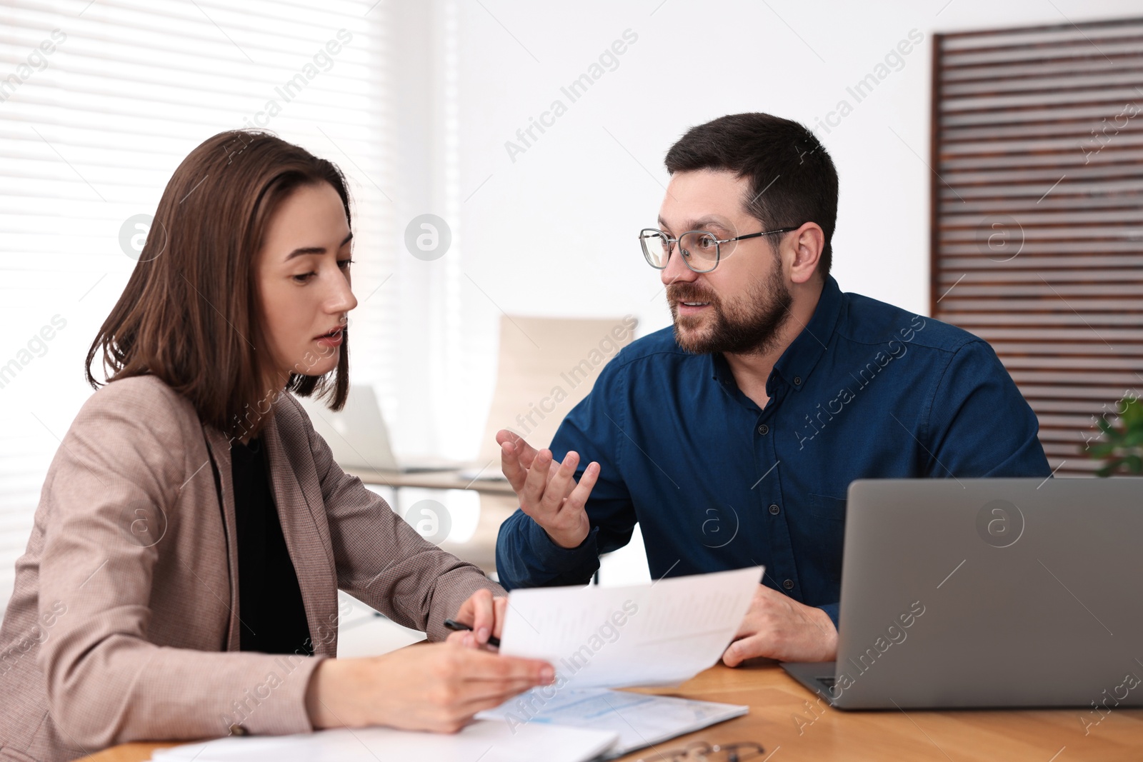 Photo of Consultant working with client at table in office