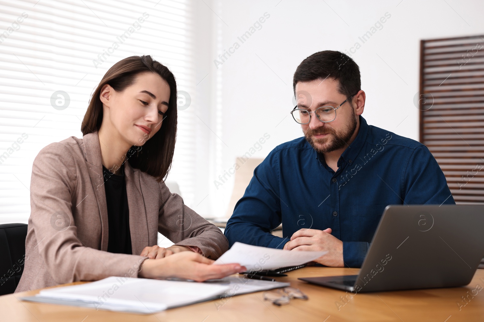 Photo of Consultant working with client at table in office