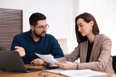 Photo of Consultant working with client at table in office
