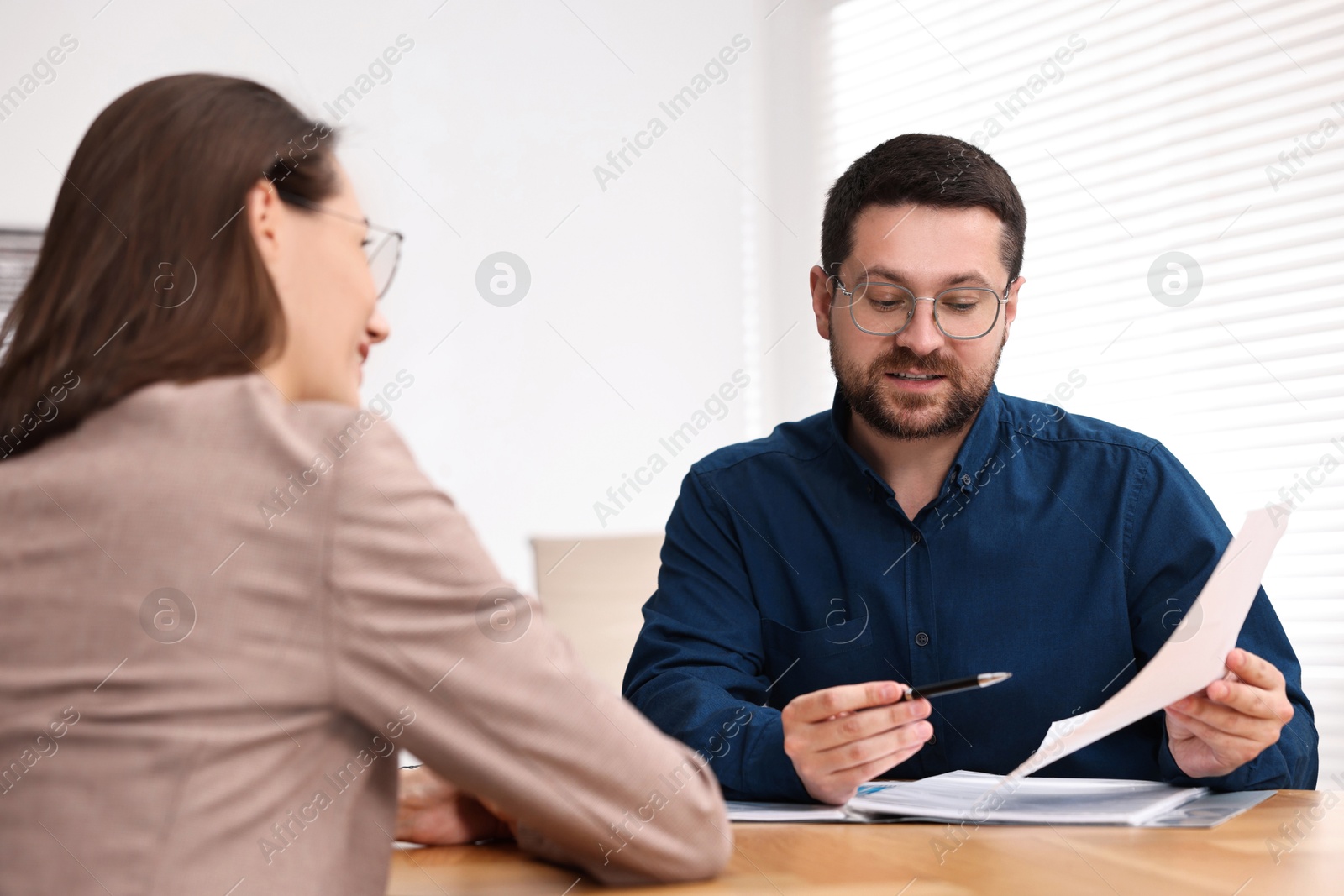 Photo of Consultant working with client at table in office