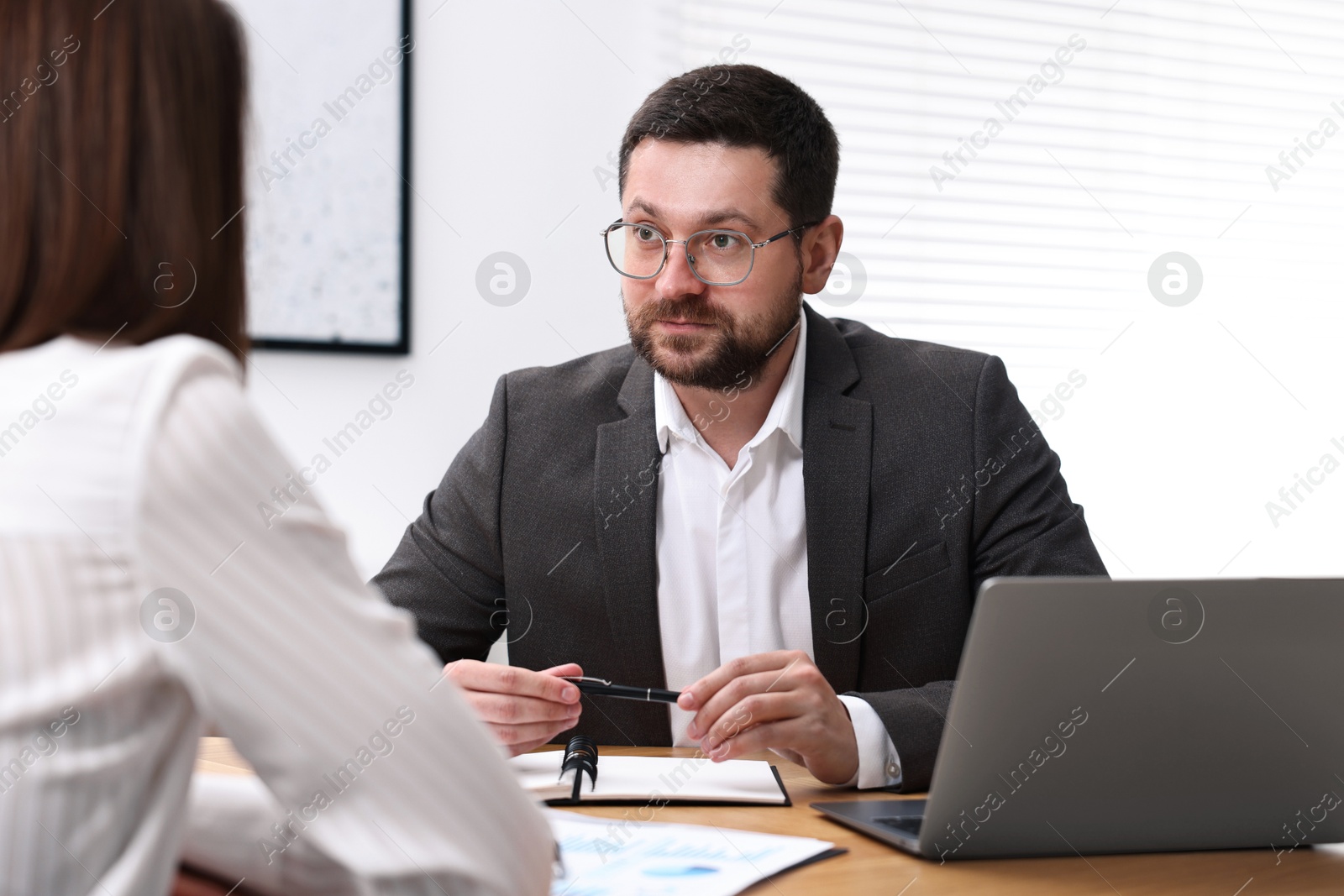 Photo of Consultant working with client at table in office