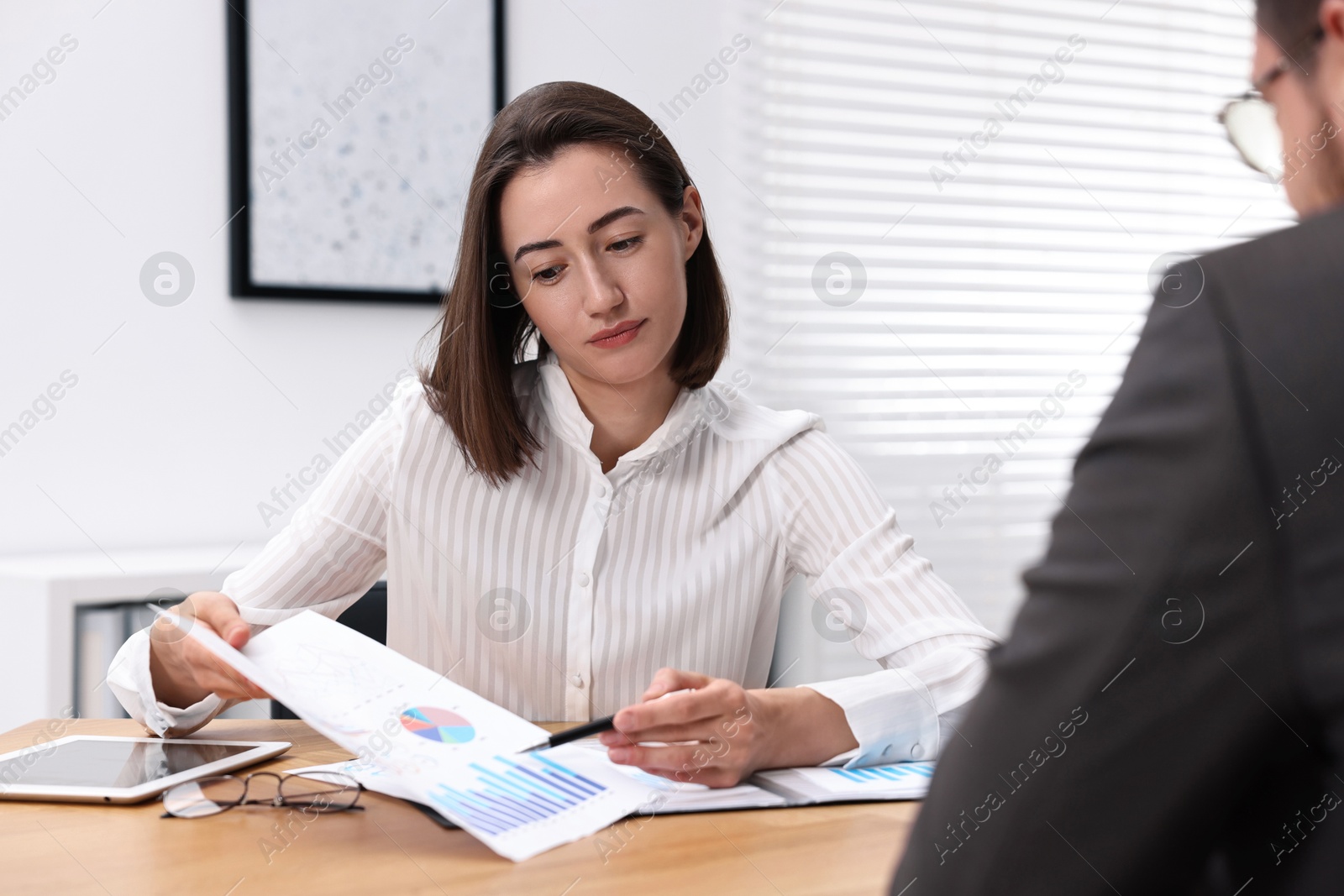 Photo of Consultant working with client at table in office