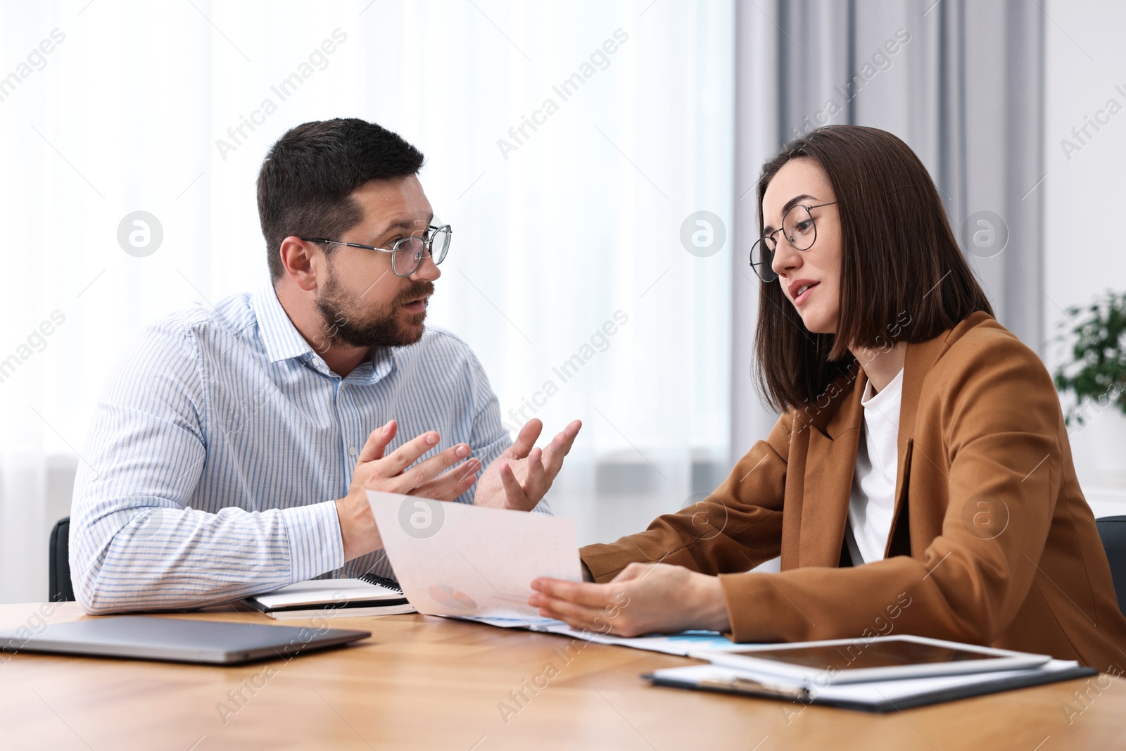 Photo of Consultant working with client at table in office