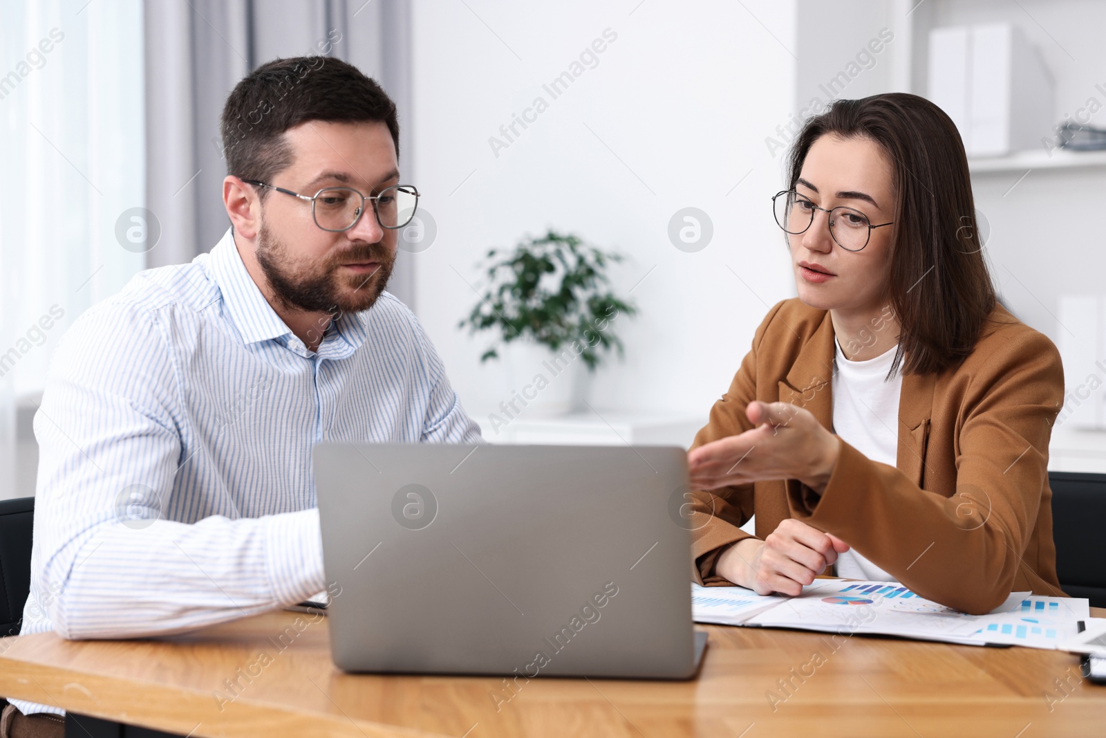 Photo of Consultant working with client at table in office