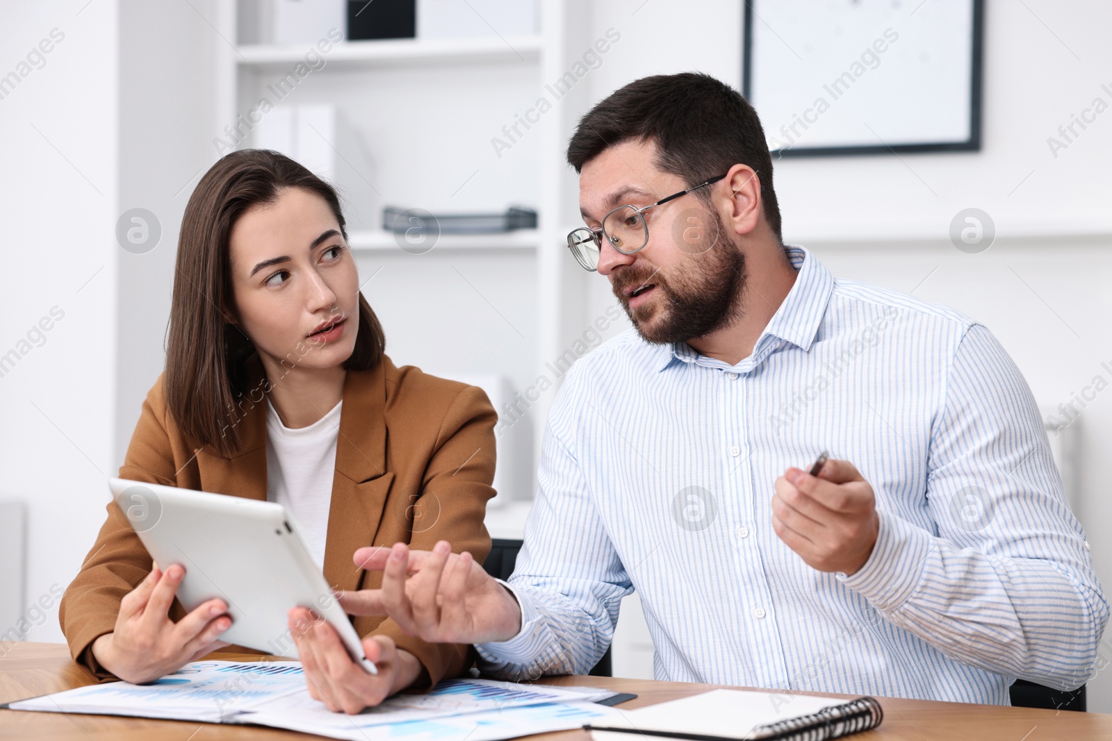 Photo of Consultant working with client at table in office