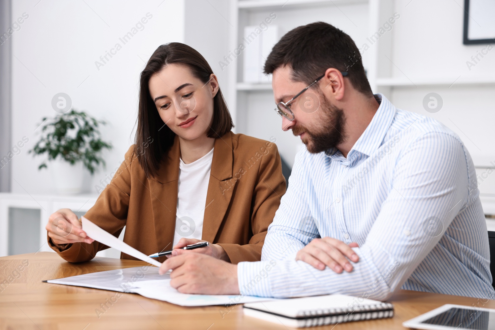 Photo of Consultant working with client at table in office