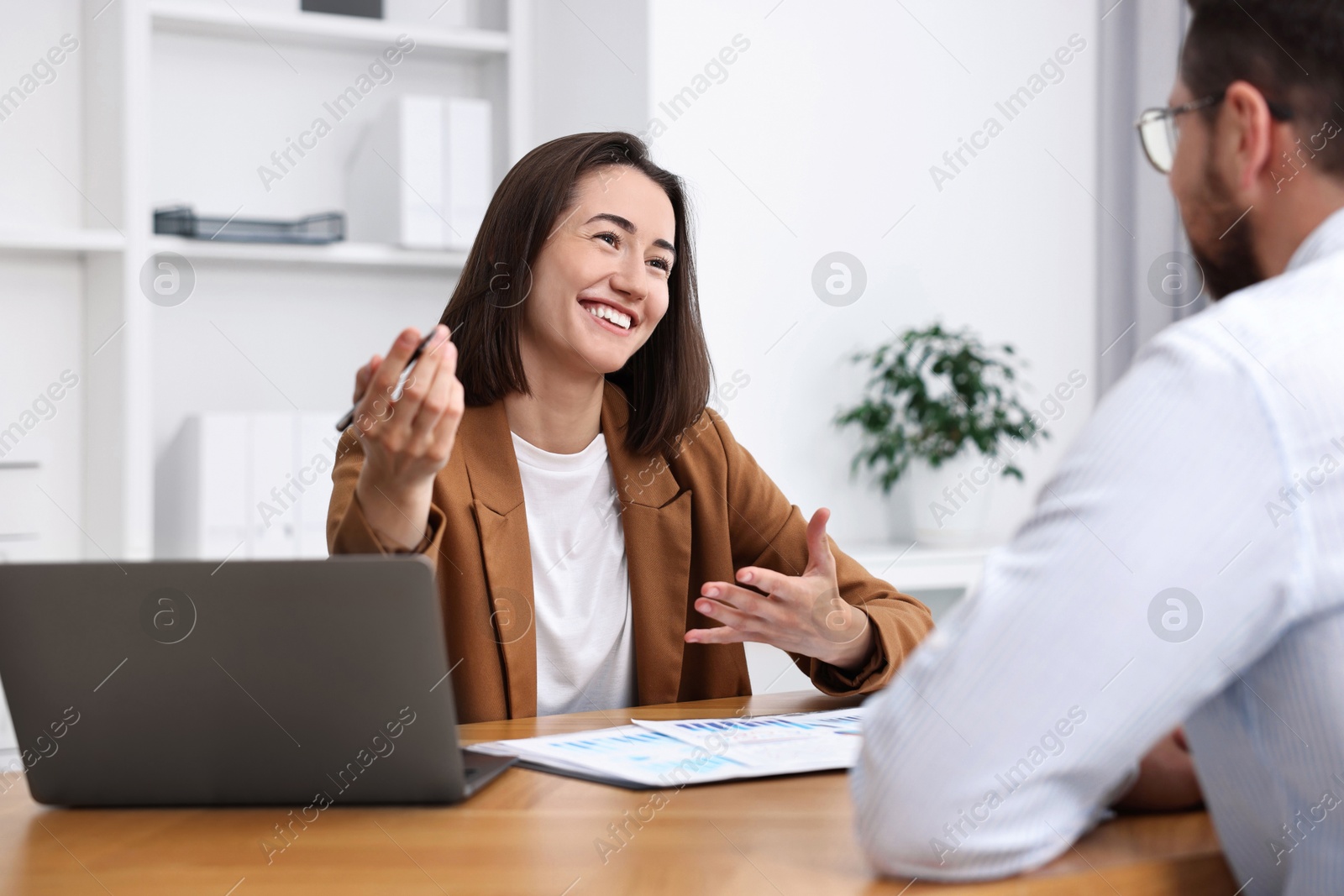 Photo of Consultant working with client at table in office