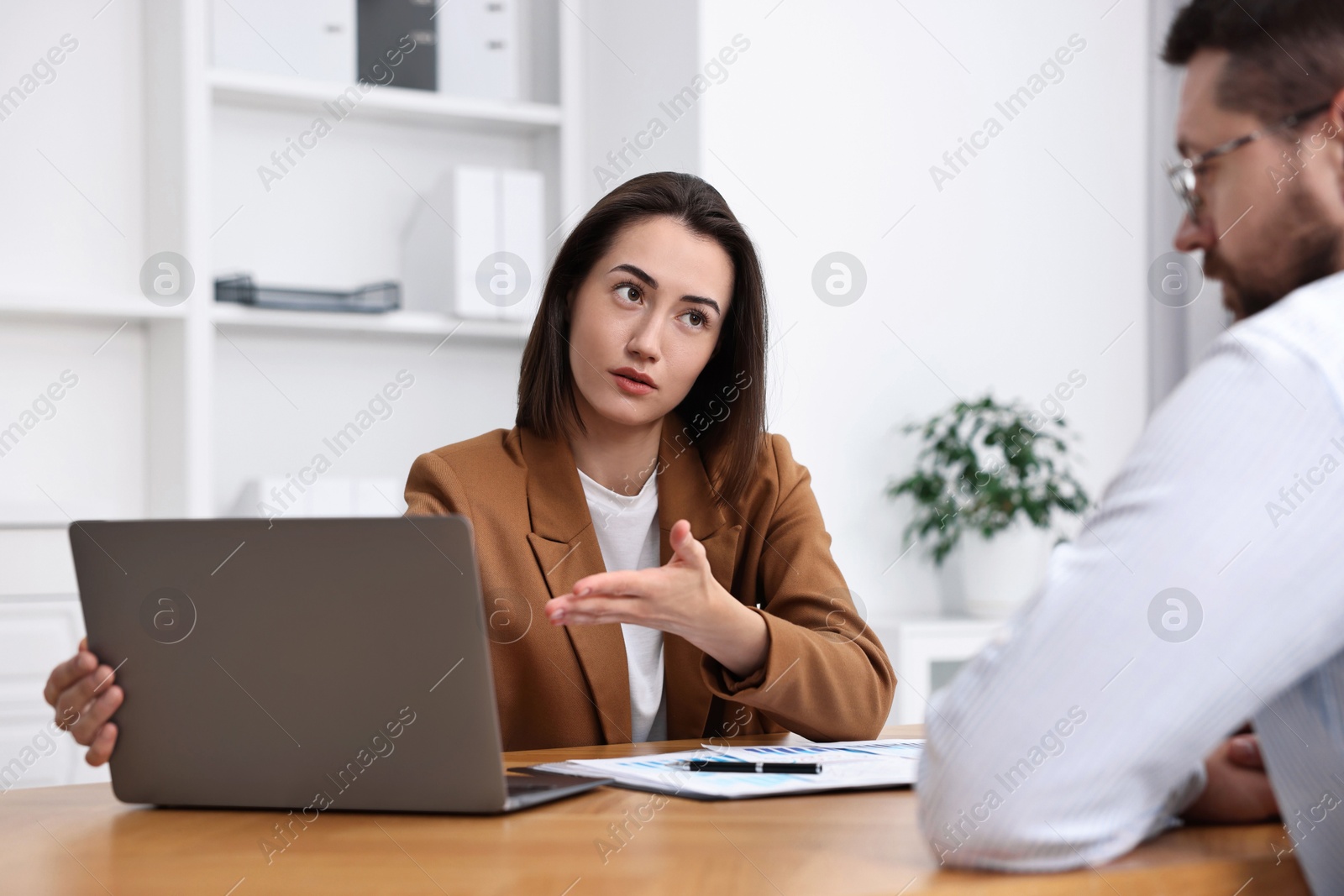 Photo of Consultant working with client at table in office