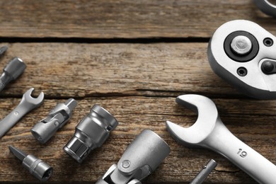 Photo of Different auto mechanic's tools on wooden table, flat lay. Space for text