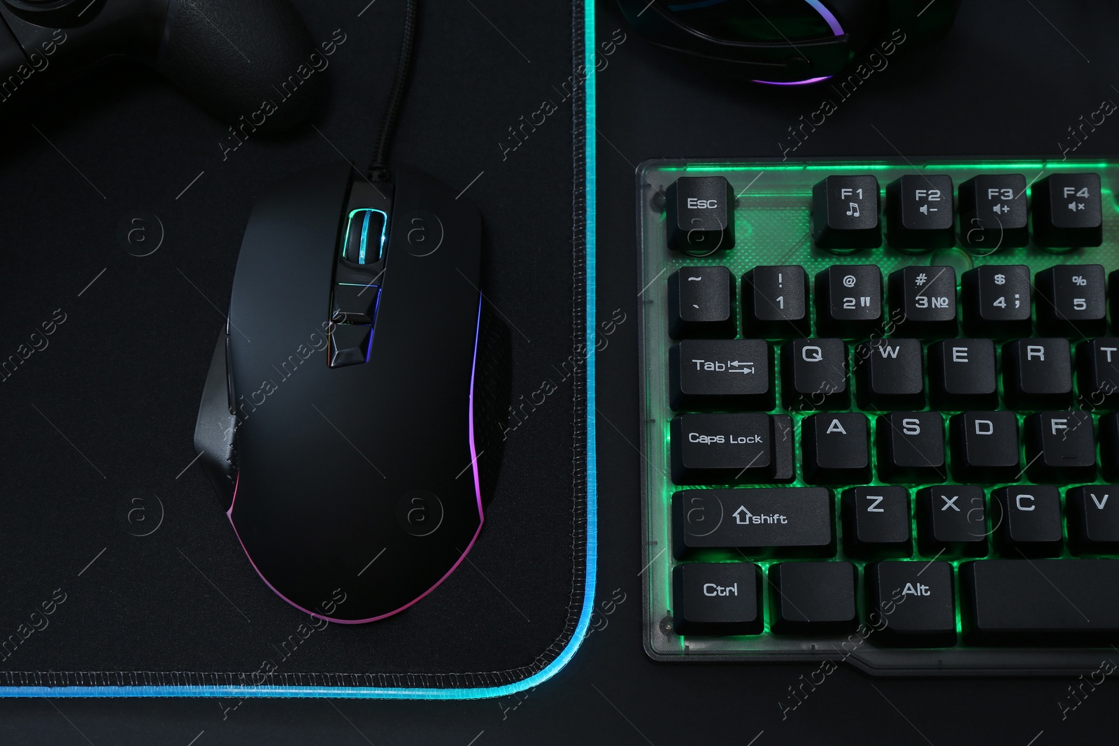 Photo of Computer mouse, RGB keyboard and game controller on black background, top view