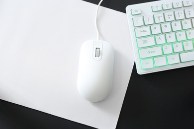 Photo of Computer mouse, mousepad and RGB keyboard on black background, top view