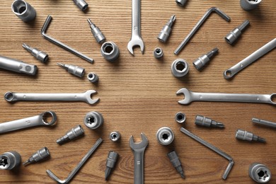 Photo of Different auto mechanic's tools on wooden table, flat lay. Space for text