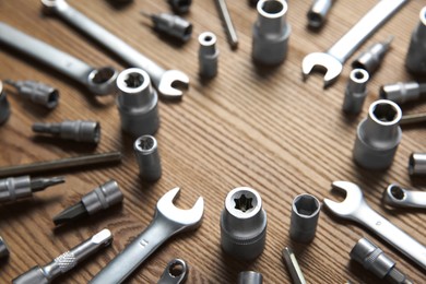 Photo of Different auto mechanic's tools on wooden table, space for text