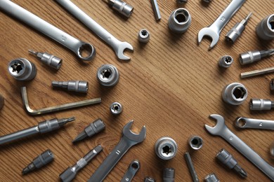 Photo of Different auto mechanic's tools on wooden table, flat lay. Space for text