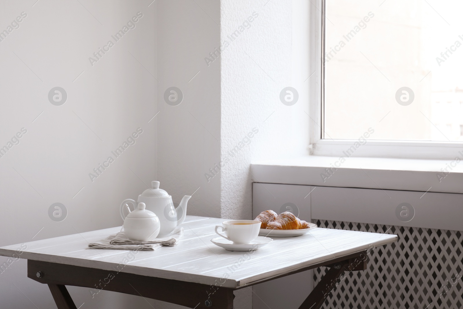 Photo of Croissants and tea on table in studio. Professional food photography