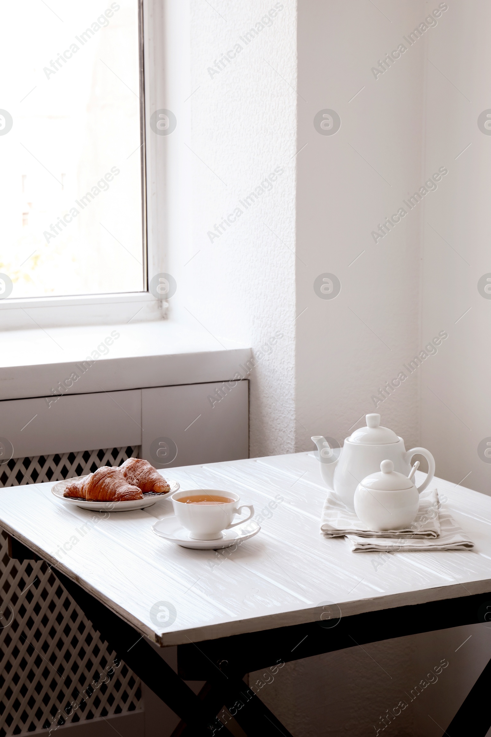 Photo of Croissants and tea on table in studio. Professional food photography