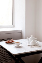 Photo of Croissants and tea on table in studio. Professional food photography