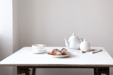 Photo of Croissants and tea on table in studio. Professional food photography