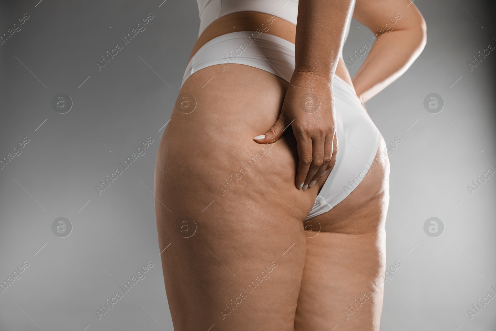 Photo of Woman with cellulite on grey background, closeup. Space for text