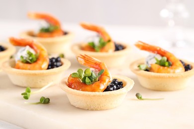 Photo of Delicious canapes with shrimps and black caviar on table, closeup